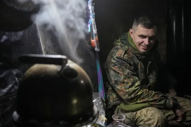 A Ukrainian serviceman of the Ukrainian 92nd Ivan Sirko Separate Assault Brigade boils water for tea inside a dugout at a position in a front line near the town of Bakhmut, amid Russia's attack on Ukraine, in Donetsk region, Ukraine on December 15, 2023. (Photo by Inna Varenytsia/Reuters)