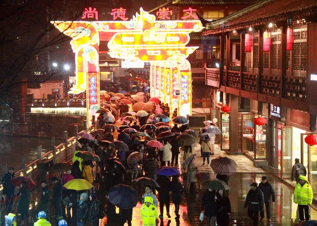 People watch illuminated lanterns during the 33rd China Qinhuai Lantern Festival at Nanjing Confucius Temple on February 18, 2019 in Nanjing, Jiangsu Province of China. People eat Tangyuan (glutinous rice balls), solve lantern riddles, watch lion dances and enjoy drum performances to celebrate the upcoming Lantern Festival, which falls on February 19 this year. (Photo by VCG/VCG via Getty Images)