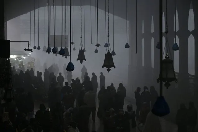 Passengers wait to board their trains at the Lahore railway station amid dense fog in Lahore on December 27, 2023. (Photo by Arif Ali/AFP Photo)