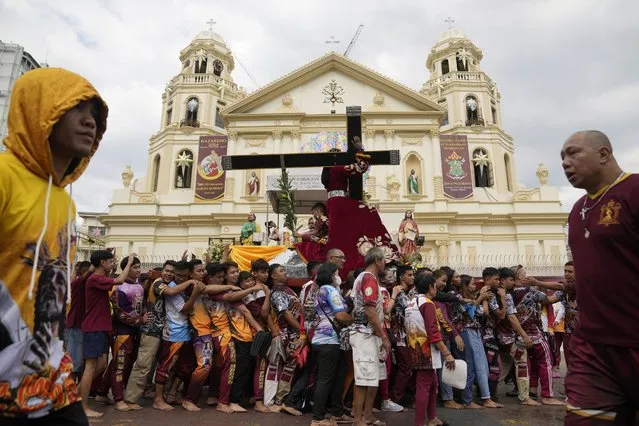 Devotees carry a replica of the Black Nazarene during the traditional blessing outside the Quiapo church in downtown Manila, Philippines, Thursday, January 4, 2024. Tens of thousands of Roman Catholic devotees are expected to join a procession to celebrate the Feast Day of the Black Nazarene on Jan. 9. (Photo by Aaron Favila/AP Photo)