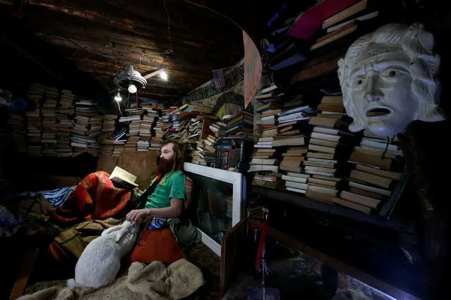 Yury Alekseyev, a former lawyer from Moscow who is called a “Russian hobbit”, pats a rabbit named Petrushka at his underground home in the forest on the side of the road northeast from Moscow, Russia February 3, 2017. (Photo by Sergei Karpukhin/Reuters)