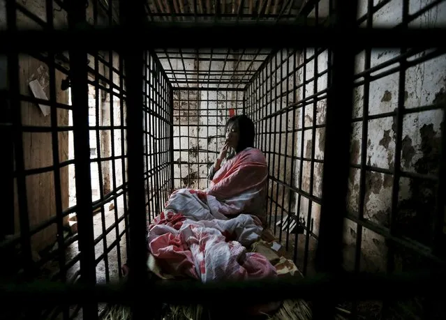 Zhao Xiaoyang smokes inside a cage at his home in Fangjia village, Zhejiang province May 6, 2015. (Photo by William Hong/Reuters)