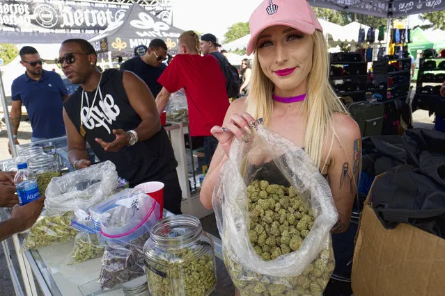 In this Saturday, April 21, 2018 file photo a bud tender offers attendees the latest products of cannabis at the High Times 420 SoCal Cannabis Cup in San Bernardino, Calif. Businesses inside and outside the multibillion-dollar cannabis industry are using April 20, or “420,” to roll out marketing and social media messaging aimed at connecting with marijuana enthusiasts. (Photo by Richard Vogel,/AP Photo/File)