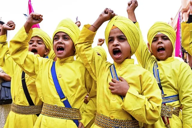 Children take part in the “Nagar Kirtan” procession on the eve of the birth anniversary of Guru Nanak Dev, the founder of Sikhism, at the Golden Temple in Amritsar on November 18, 2021. (Photo by Narinder Nanu/AFP Photo)