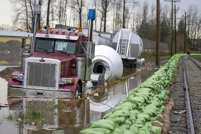 A truck gets swallowed up by rising floodwaters from the United States as waters cross the border into Abbotsford, British Columbia, Monday, November 29, 2021. (Photo by Jonathan Hayward/The Canadian Press via AP Photo)