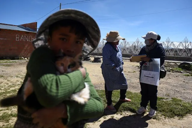 A child plays with a cat while his mother takes part in the National Population and Housing Census in the Mercedario area, in El Alto, Bolivia on March 23, 2024. (Photo by Claudia Morales/Reuters)