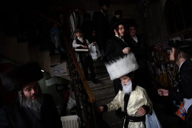 Jewish ultra-Orthodox men and children, some wearing costumes, celebrate the Jewish festival of Purim at a synagogue in Bnei Brak, Israel, Sunday, March 24, 2024. The Jewish holiday of Purim commemorates the Jews salvation from genocide in ancient Persia, as recounted in the Book of Esther. (Photo by Oded Balilty/AP Photo)