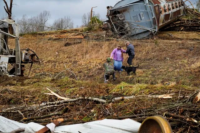 Local residents walk past the scene of a train derailment after a devastating outbreak of tornadoes ripped through several U.S. states in Earlington, Kentucky, U.S. December 11, 2021. (Photo by Cheney Orr/Reuters)