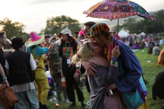 A couple embrace during sunset at Glastonbury Festival at Worthy farm in Somerset, Britain on June 26, 2019. (Photo by Henry Nicholls/Reuters)