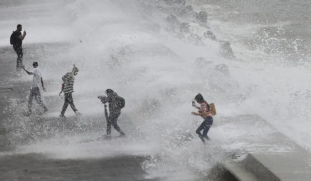 People are drenched by waves during high tide by the Arabian Sea in Mumbai, India, Thursday, July 4, 2019. (Photo by Rafiq Maqbool/AP Photo)