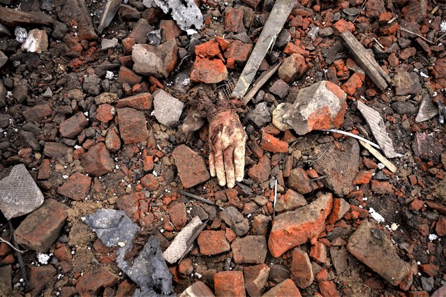 A severed hand lies in the rubble of a house where Ukrainian servicemen were sheltering which destroyed by a Russian S-300 rocket strike, in Kupiansk, Ukraine, Monday, February 20, 2023. Grueling artillery battles have stepped up in recent weeks in the vicinity of Kupiansk, a strategic town on the eastern edge of Kharkiv province by the banks of the Oskil River as Russian attacks intensifying in a push to capture the entire industrial heartland known as the Donbas, which includes the Donetsk and the Luhansk provinces. (Photo by Vadim Ghirda/AP Photo)