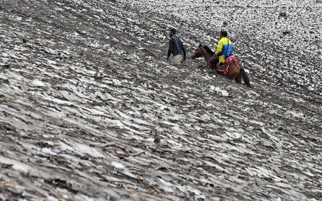 Hindu pilgrims trek on horses up to the glacier at Chandanwari, some 115 km southeast of Srinagar, during the annual Hindu pilgrimage on July 27, 2019 to the holy cave shrine of Amarnath. Every year, hundreds of thousands of pilgrims trek through treacherous mountains in revolt-torn Kashmir, along icy streams, glacier-fed lakes and frozen passes, to reach the Amarnath cave, located at an altitude of 3880 m (12,729 feet), where a Shiva Lingam, an ice stalagmite shaped like a phallus and symbolising the Hindu God Shiva, stands for worship. (Photo by Tauseef Mustafa/AFP Photo)