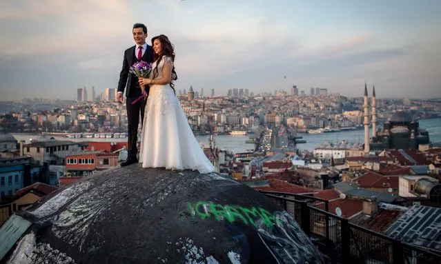 A newlywed couple pose for photographs on a rooftop of an old Istanbul Han overlooking the Bosphorus strait on March 18, 2017 in Istanbul, Turkey. Turkey will hold its constitutional referendum on April 16, 2017. Turks will vote on 18 proposed amendments to the Constitution of Turkey. The controversial changes seek to replace the parliamentary system and move to a presidential system which would give President Recep Tayyip Erdogan executive authority. (Photo by Chris McGrath/Getty Images)