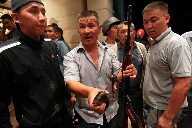 Armed supporters of Almazbek Atambayev guard his house in the village of Koi Tash near Bishkek, Kyrgyzstan August 7, 2019. The Kyrgyz State Committee on National Security confirmed its special forces unit was seeking to detain Atambayev at the village outside the capital Bishkek and had used rubber bullets. An Atambayev-controlled television station, April, broadcast footage in which gunshots could be heard and armed men seen around the building wearing camouflage and bulletproof vests. (Photo by Vladimir Pirogov/Reuters)