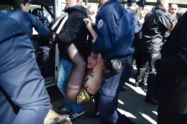 French police officers detain a topless Femen activist during a protest outside a banquet held by France's far-right Front National (FN) party in honour of Jeanne d'Arc (Joan of Arc) at the Porte de La Villette in Paris on May 1, 2016. (Photo by Alain Jocard/AFP Photo)