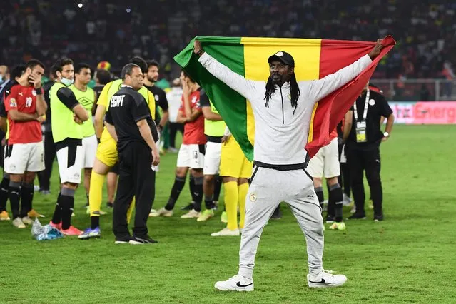 Senegal's head coach Aliou Cisse holds a Senegalese flag as he celebrates after winning the Africa Cup of Nations (CAN) 2021 final football match between Senegal and Egypt at Stade d'Olembe in Yaounde on February 6, 2022. (Photo by Charly Triballeau/AFP Photo)