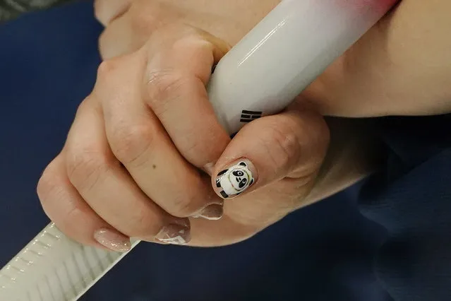 South Korea's Kim Kyeong-ae has Bing Dwen Dwen, the Beijing Winter Olympics mascot, on her nails during a women's curling match against Britain at the Beijing Winter Olympics Friday, February 11, 2022, in Beijing. (Photo by Brynn Anderson/AP Photo)