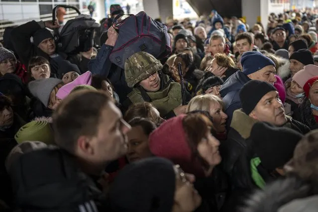 A Ukrainian soldier tries to disperse the crowd as they push to enter a train to Lviv at the Kyiv station, Ukraine, Friday, March 4. 2022. (Photo by Emilio Morenatti/AP Photo)