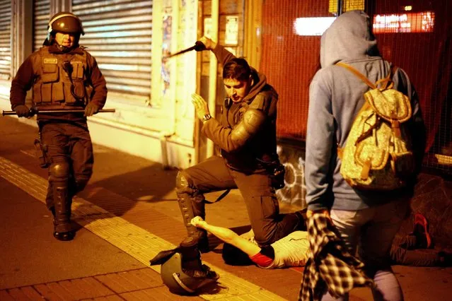 A protester is arrested by the police  after a rally in favor of fishermen affected by the red tide in Puerto Montt, Chile, 12 May 2016. The red tide is caused by the excessive proliferation of microalgae with high concentrations of toxins, which can cause illness in humans and animals. (Photo by Sebastian Silva/EPA)