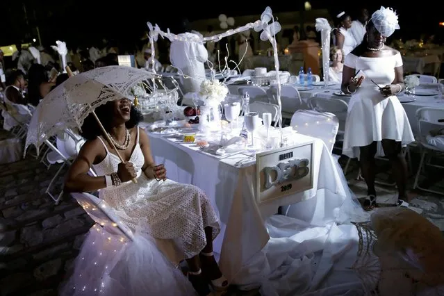 An attendee laughs as she poses for a photo during 2019 Haiti Diner en Blanc event in Cap Haitien, Haiti, August 10, 2019. (Photo by Andres Martinez Casares/Reuters)