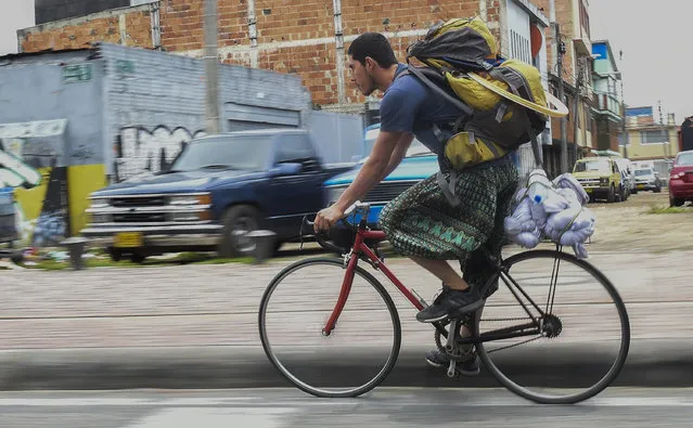 Colombian Jahn Fredy Duque rides his bike to the spot where he will perform on the streets in Bogota, Colombia, dressed up as superhero “Spiderman”, on April 24, 2017. (Photo by Raul Arboleda/AFP Photo)