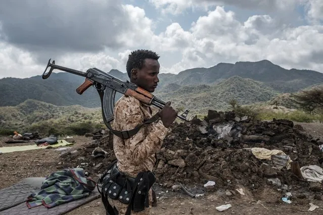 A member of the Afar Special Forces stands in front of the debris of a house in the outskirts of the village of Bisober, Tigray Region, Ethiopia, on December 09, 2020.Several houses in the village were damaged during the confrontations between the Tigray Forces and the Ethiopian Defense Forces. (Photo by Eduardo Soteras/AFP Photo)