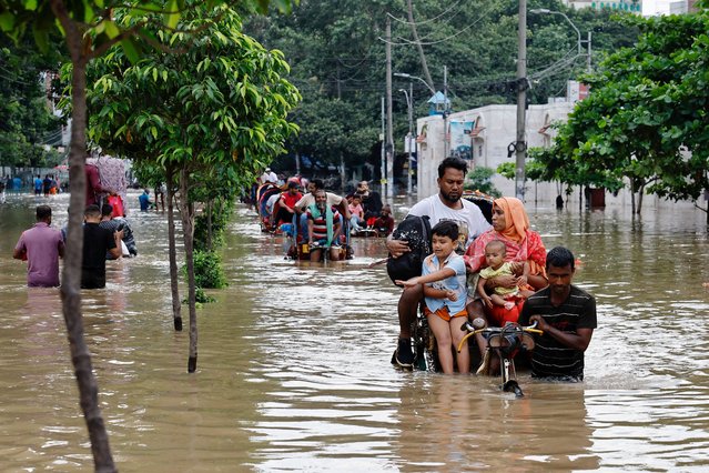 People move on rickshaws along a flooded street after a downpour in Dhaka, Bangladesh, on July 12, 2024. (Photo by Mohammad Ponir Hossain/Reuters)