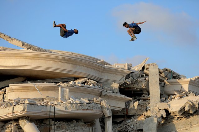 Palestinian parkour athletes jump over the debris of demolished buildings following the Israeli attacks to draw attention to the destruction caused by the Israeli forces in Bureij, Deir al-Balah, Gaza on July 9, 2024. (Photo by Hassan Jedi/Anadolu via Getty Images)