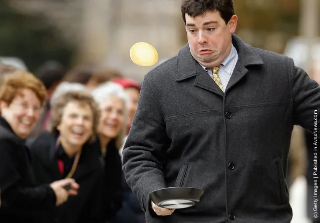 A competitor looses control of his pancake while racing during the Shrove Tuesday, or Mardi Gras, tradition at the National Cathedral