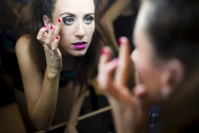 A participant adjusts her make-up backstage during a Latin dance competition in Tel Aviv, Israel July 18, 2015. (Photo by Amir Cohen/Reuters)