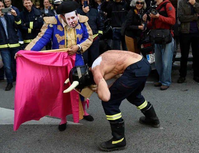 Firefighters simulate a bullfight during a protest in front of the regional parliament of Asturias to demand more staff and better conditions in Oviedo, northern Spain, May 26, 2016. (Photo by Eloy Alonso/Reuters)