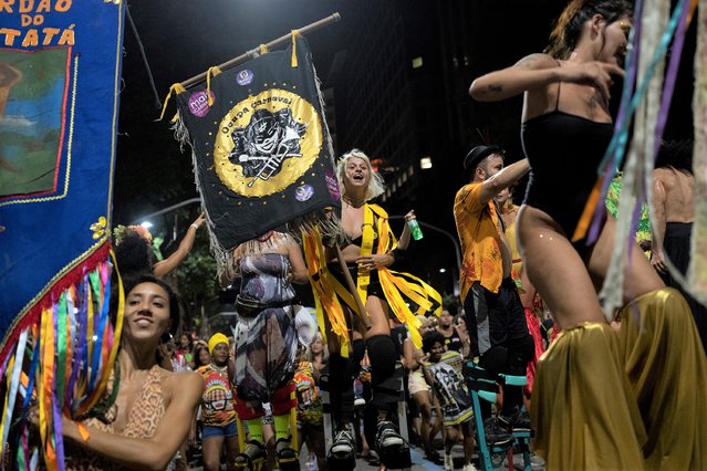 Revellers of street parties known as blocos, dance during a protest against restrictions by city officials in Rio de Janeiro, Brazil, Wednesday, April 13, 2022. City Hall has banned the street parties during Carnival celebrations, which were delayed by almost two months due to the pandemic. (Photo by Silvia Izquierdo/AP Photo)