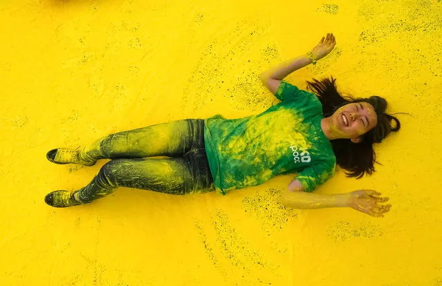 A volunteer lies on colored powder during the YARKOcross colour run race in Almaty, Kazakhstan, June 5, 2016. (Photo by Shamil Zhumatov/Reuters)