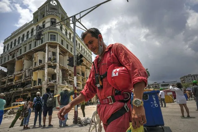 A member of the Cuban Red Cross takes a break after working in the rubble at the site of a deadly explosion that destroyed the five-star Hotel Saratoga in Old Havana, Cuba, Monday, May 9, 2022. (Photo by Ramon Espinosa/AP Photo)