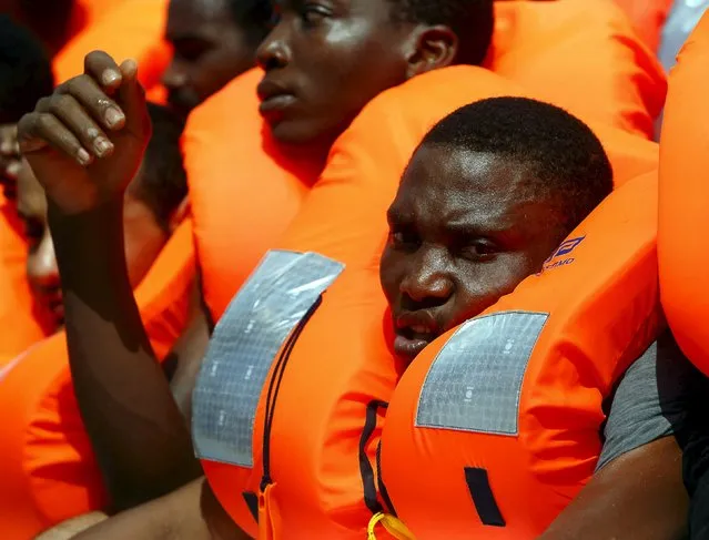 Migrants on a rubber dinghy wait to be rescued by the Migrant Offshore Aid Station (MOAS) ship MV Phoenix, some 20 miles (32 kilometres) off the coast of Libya, August 3, 2015. (Photo by Darrin Zammit Lupi/Reuters)