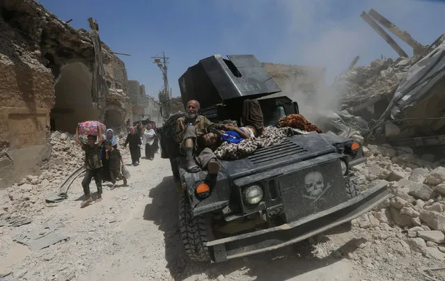 Displaced Iraqi civilians who fled from clashes ride in a military vehicle in the Old City of Mosul, Iraq, July 1, 2017. (Photo by Alaa Al-Marjani/Reuters)