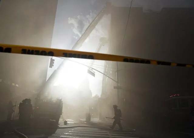Members of the New York City Fire Department (FDNY) work at a Five alarm fire on 8th street and Broadway in New York, USA, 28 June 2017. According to reports, dozens of firefighters battled the fire. (Photo by Jason Szenes/EPA)
