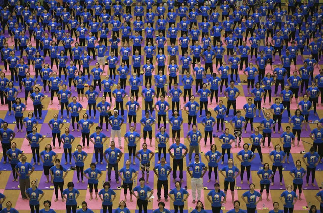 People demonstrate a yoga pose in an indoor stadium in Hanoi, Vietnam, Sunday, July 26, 2016. About 1,000 yoga practitioners participated in the mass practice to celebrate the annual International Yoga Day. (Photo by Hau Dinh/AP Photo)
