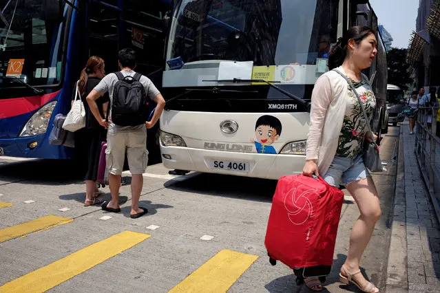 Tourists get on and off tour buses outside a hotel in Hong Kong, China July 30, 2017. (Photo by Bobby Yip/Reuters)