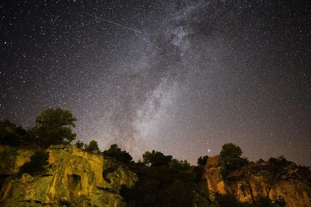 Perseid meteors streak across the night sky over the ancient city of Mesotimolos in Esme district of Turkey's western Usak province on August 13, 2019. Visitors observed 60 to 80 meteors that were visible with the naked eye. (Photo by Soner Kilinc/Anadolu Agency via Getty Images)