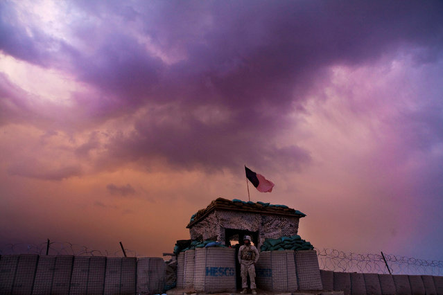 A U.S. Marine from the First Battalion Eighth Marines Alpha Company looks out as an evening storm gathers above an outpost near Kunjak in southern Afghanistan's Helmand province, February 22, 2011. (Photo by Finbarr O'Reilly/Reuters)