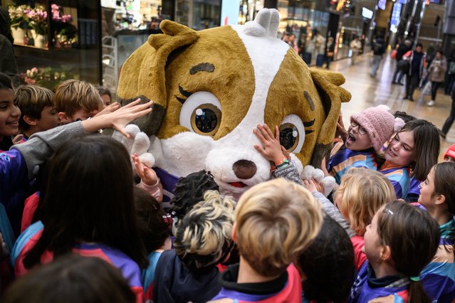 Children gather around Maddli, the mascot of the upcoming UEFA Women's EURO 2025 football tournament during its official unveiling at Geneva train station on November 29, 2024. Sixteen national football teams will play a total of 31 matches in eight host cities across Switzerland over a four-week period from July 2 to July 27, 2025. (Photo by Fabrice Coffrini/AFP Photo)