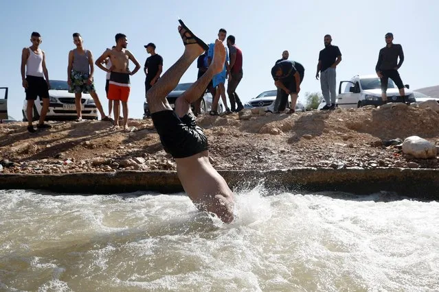 Palestinians cool off during a heat wave, in al-Oja springs near Jericho in the Israeli-Occupied West Bank on July 22, 2022. (Photo by Mohamad Torokman/Reuters)