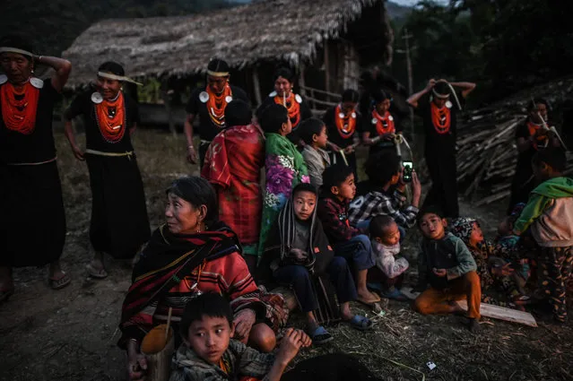 This photo taken on February 7, 2020 shows villagers watching the end of an overnight ceremony to bless the harvest by Naga tribeswomen in Satpalaw Shaung village, Lahe township in Myanmar's Sagaing region. (Photo by Ye Aung Thu/AFP Photo)