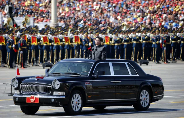 Chinese President Xi Jinping stands in a car to review the army during a parade commemorating the 70th anniversary of Japan's surrender during World War II held in front of Tiananmen Gate in Beijing, Thursday, September 3, 2015. The spectacle involved more than 12,000 troops, 500 pieces of military hardware and 200 aircraft of various types, representing what military officials say is the Chinese military's most cutting-edge technology. (Photo by Ng Han Guan/AP Photo)