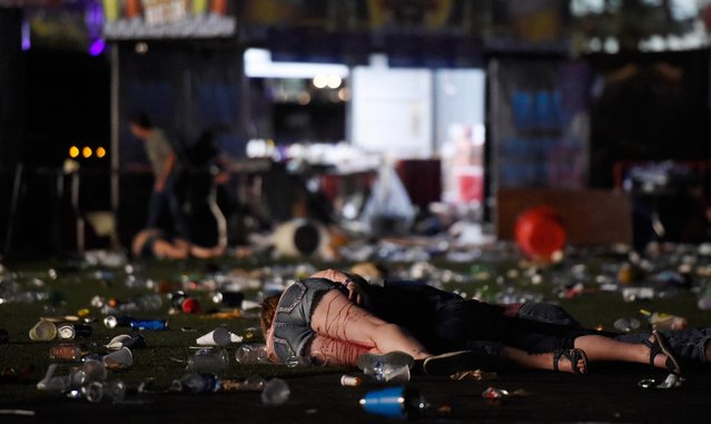 A person lies on the ground covered with blood at the Route 91 Harvest country music festival after apparent gun fire was heard on October 1, 2017 in Las Vegas, Nevada. There are reports of an active shooter around the Mandalay Bay Resort and Casino. (Photo by David Becker/Getty Images)