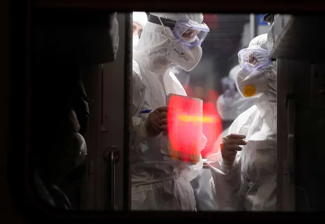 Medical staff members check the Ukrainian citizens evacuated by train from Latvia due of the spread of the coronavirus disease (COVID-19), upon arrival at the central railway station in Kiev, Ukraine on March 23, 2020. (Photo by Gleb Garanich/Reuters)