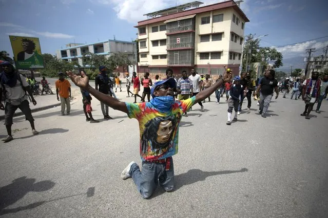 A demonstrator prays on his knees during a protest to demand the resignation of Prime Minister Ariel Henry in the Petion-Ville area of Port-au-Prince, Haiti, Monday, October 3, 2022. (Photo by Joseph Odelyn/AP Photo)