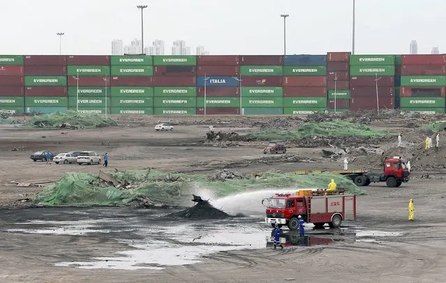 A firefighter truck sprays liquid as workers clean up the centre of the explosions on August 12 at Binhai new district in Tianjin, China, September 11, 2015. (Photo by Reuters/Stringer)