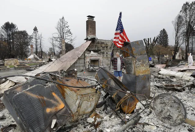 Larry Keyser looks around as he and volunteers from Samaritan's Purse disaster relief sift through remains of his family's home destroyed by fires in the Coffey Park area of Santa Rosa, Calif., Wednesday, November 8, 2017. Rumbling front loaders began scraping up the ash and rubble of nearly 9,000 destroyed homes and other structures in Northern California this week as the U.S. Army Corps of Engineers launched a new phase of the largest wildfire clean-up in the state's history. (Photo by Jeff Chiu/AP Photo)